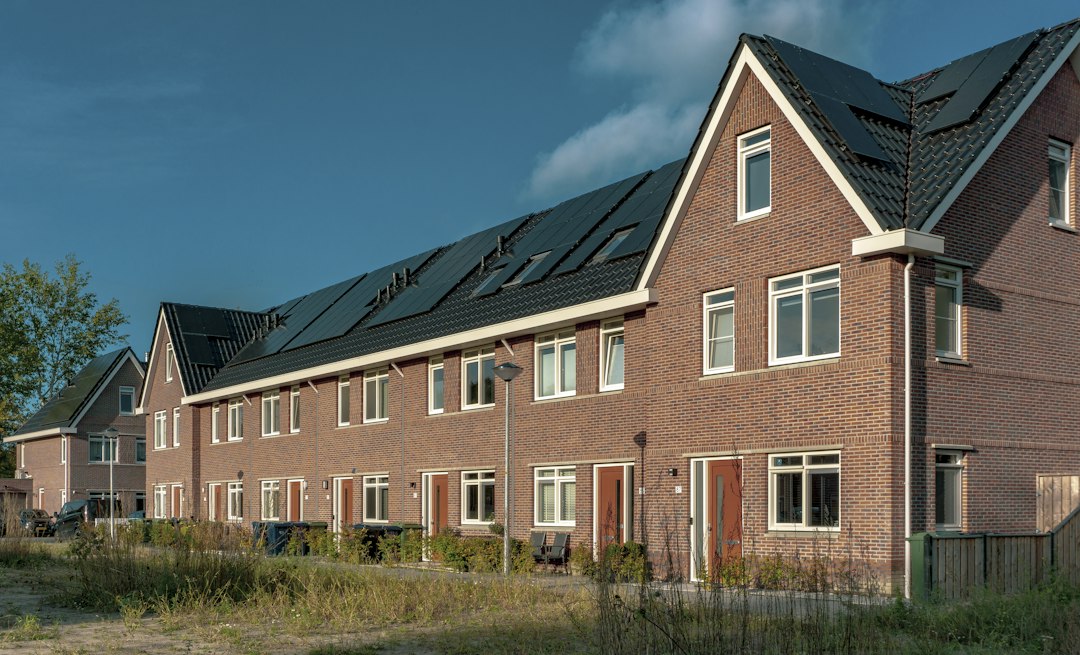 Rij woningen met zonnepanelen in een Nederlandse wijk